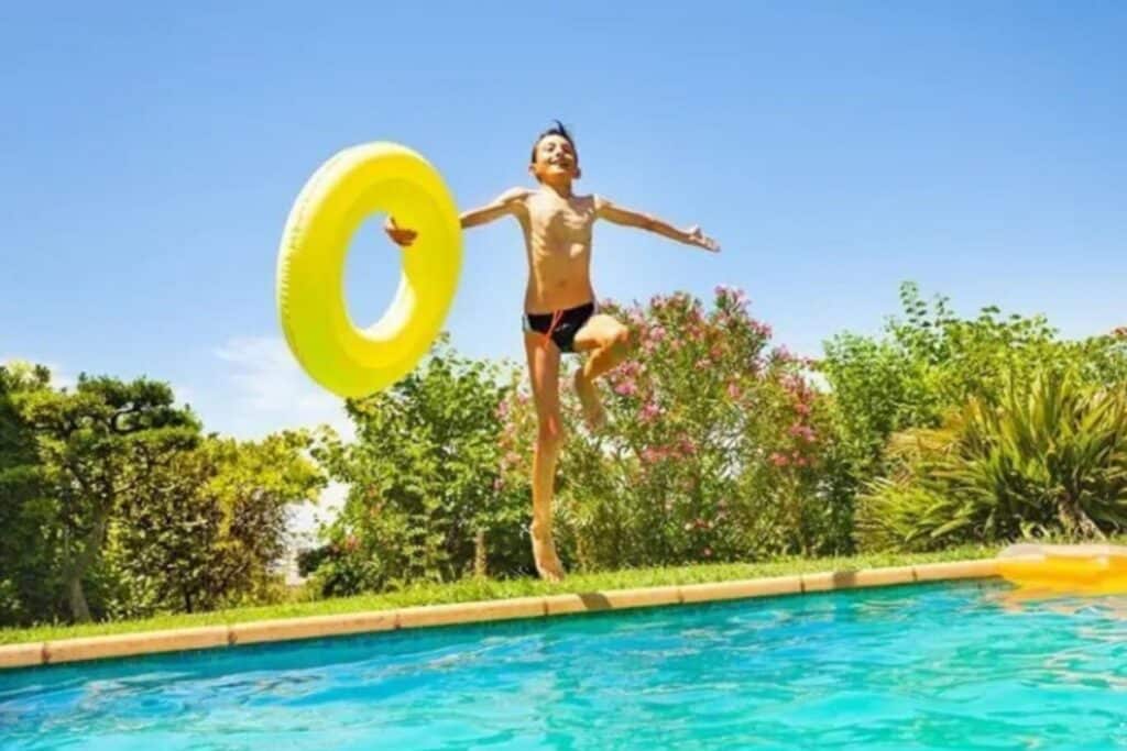 enfant saute piscine du camping