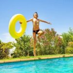 enfant saute piscine du camping