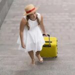femme avec une grosse valise jaune