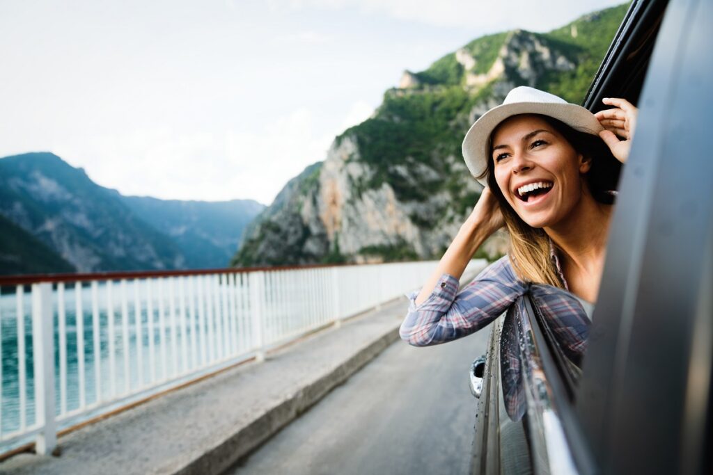 femme heureuse qui sort la tête d'une voiture