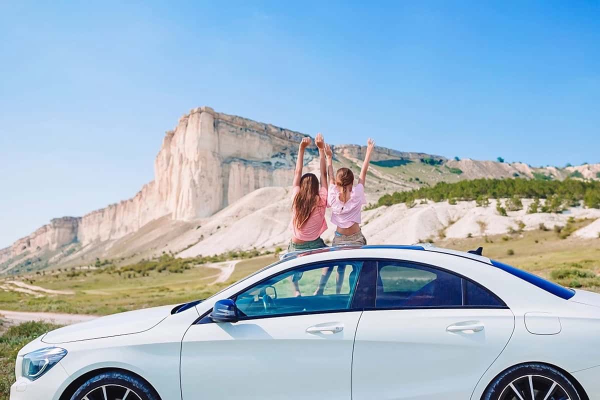 couple heureux en voyage avec voiture