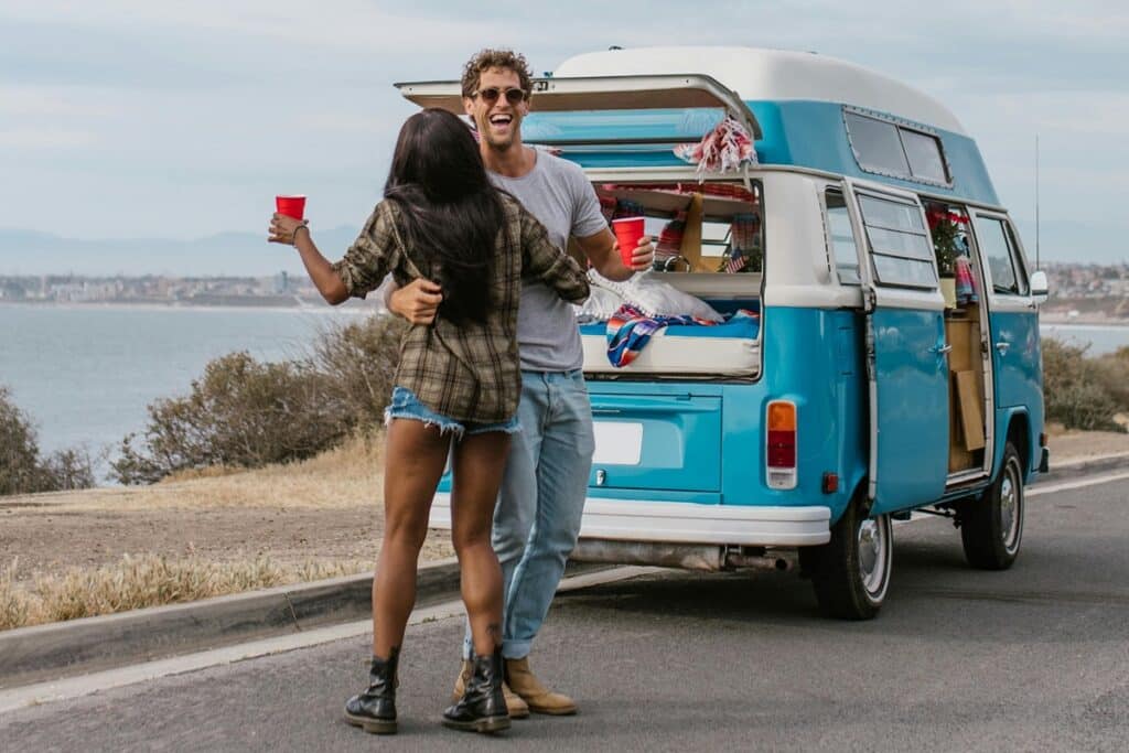 jeune couple heureux devant leur camping car