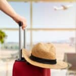 bras de femme tenant sa valise pour voyager sereinement