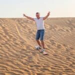 homme surfant sur les dunes de sable au Moyen-Orient