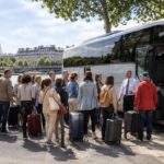 grand groupe de voyageurs près d'un bus à Paris