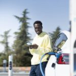 homme qui attend que sa voiture électrique recharge