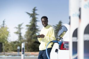 homme qui attend que sa voiture électrique recharge