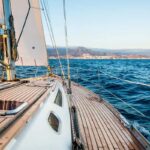 voilier en mer, avant du bateau et terre au loin