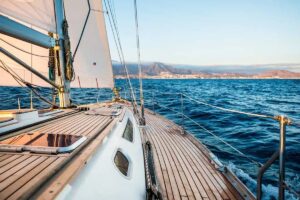 voilier en mer, avant du bateau et terre au loin